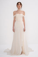 Elegant Harmonia Dress by Manel-Fashion displayed on a hanger, showcasing its flowing fabric and stylish design.