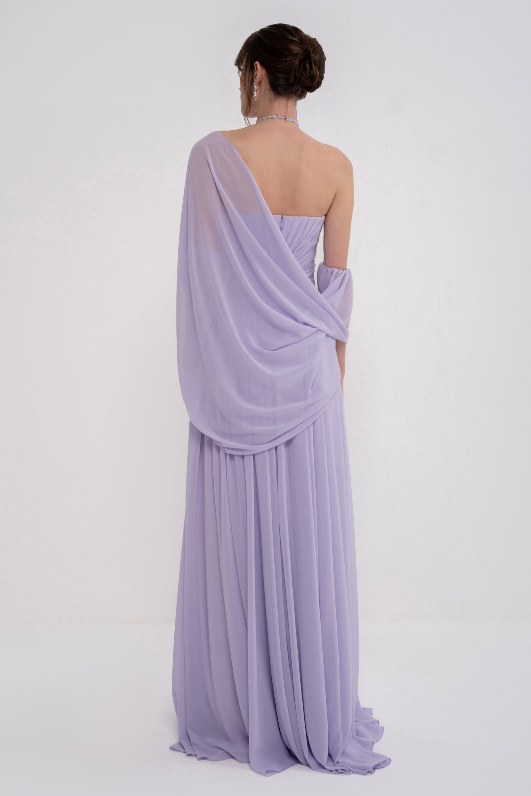 Woman wearing the elegant HERA dress by MANEL-FASHION, featuring a flowing design and stylish neckline.