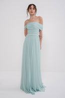 Manel-Fashion Gaia dress displayed on a hanger, featuring a stylish, flowy design with floral patterns and elegant neckline.