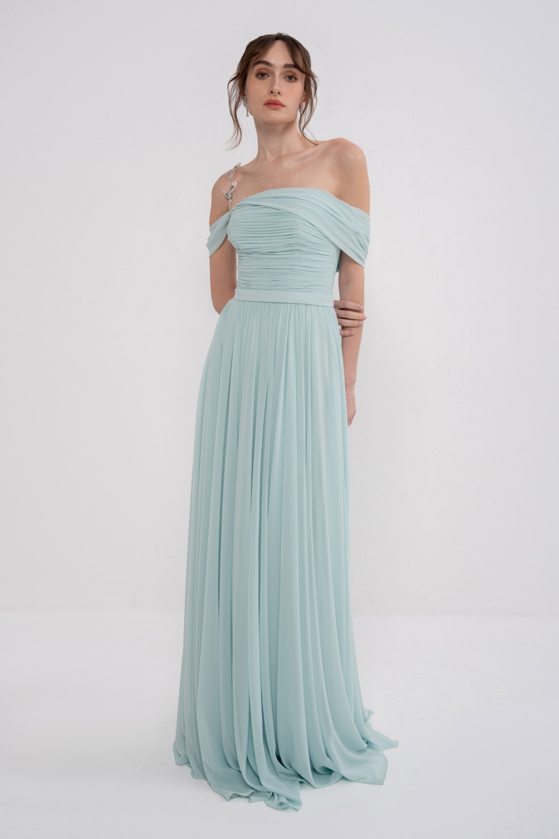 Manel-Fashion Gaia dress displayed on a hanger, featuring a stylish, flowy design with floral patterns and elegant neckline.
