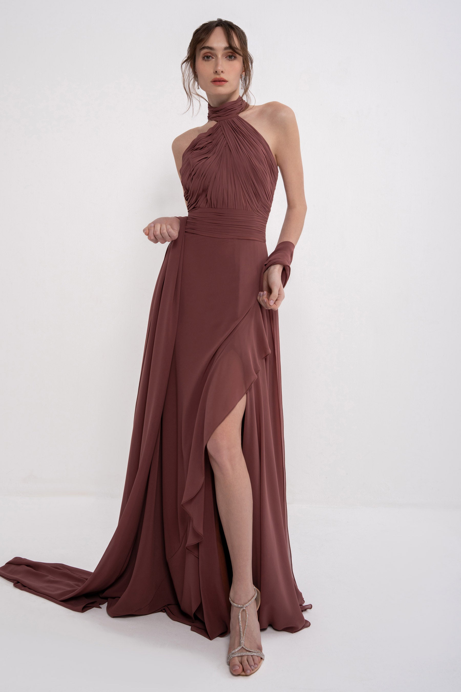 Elegant AETHER dress by MANEL-FASHION displayed on a hanger, showcasing its flowing fabric and stylish design.
