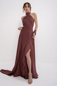 Elegant AETHER dress by MANEL-FASHION displayed on a hanger, showcasing its flowing fabric and stylish design.
