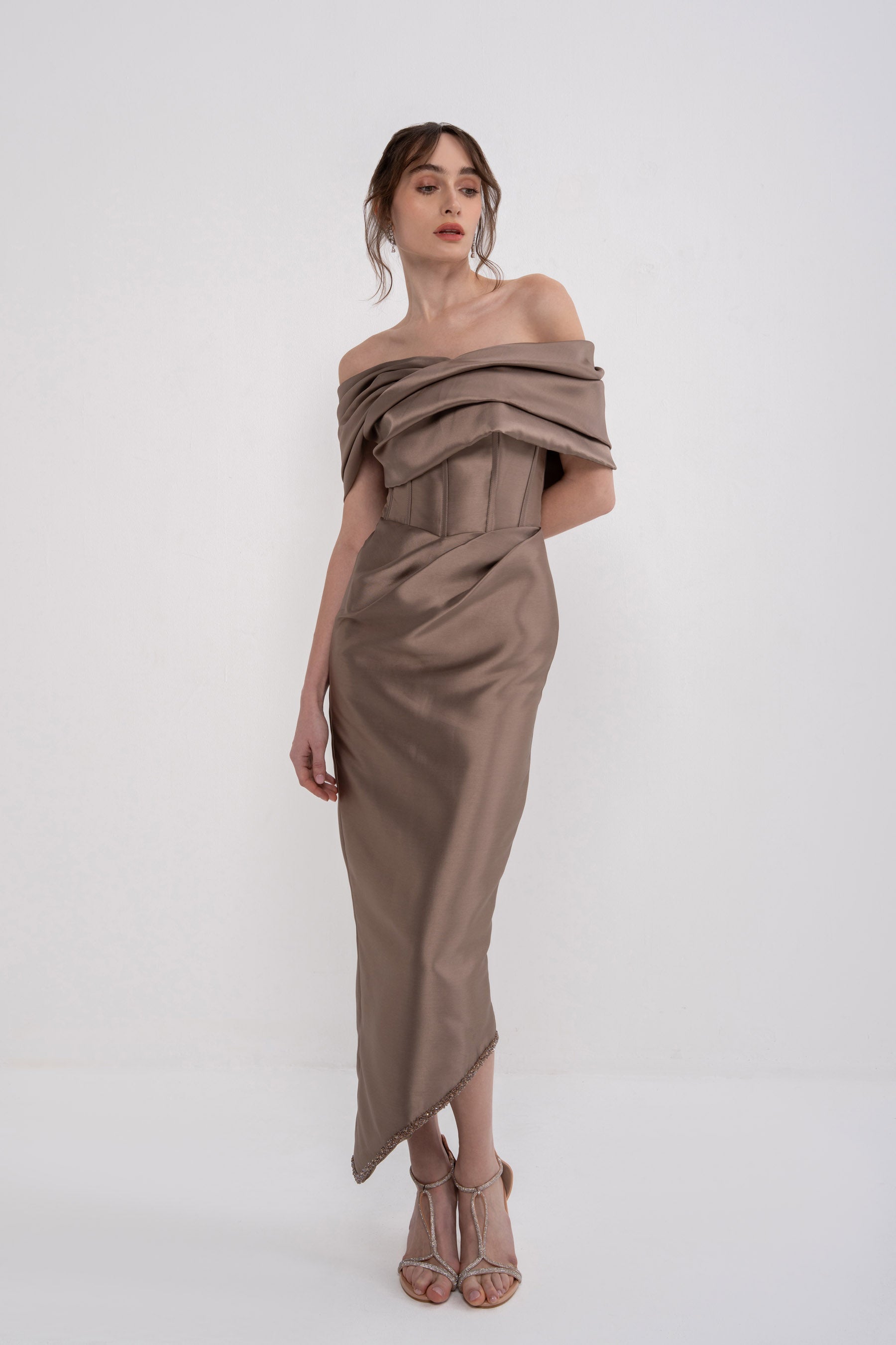Black Nera Dress by MANEL-FASHION displayed on a hanger, showcasing its elegant design and fabric details.