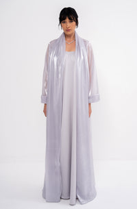 Grey CLEA dress by MANEL-FASHION displayed on a hanger, showcasing its elegant design and fabric details.
