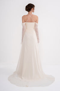 Elegant HARMONIA dress by MANEL-FASHION featuring a flowing design and intricate details, displayed on a mannequin.